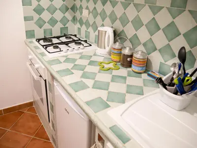 a kitchen with a counter with a stove and a sink at Madinah apartments in Palermo