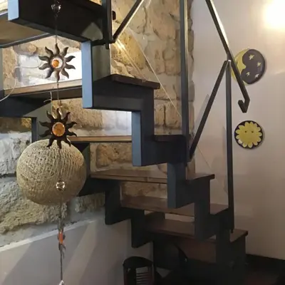 a staircase in a house with a stone wall at Il Drago e la Fenice in Palermo