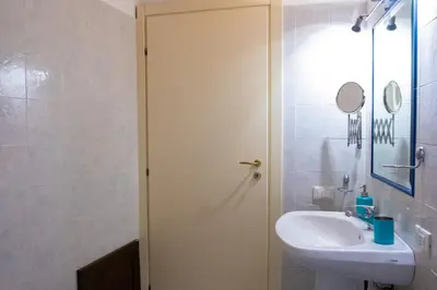 a white bathroom with a sink and a toilet at Centro Casa Monteleone in Palermo