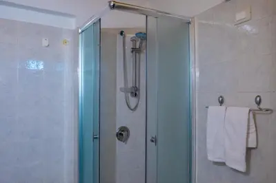 a bathroom with a shower with a glass door at Centro Casa Monteleone in Palermo