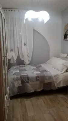 a bedroom with a bed and a light and curtains at Alla Casetta in Palermo