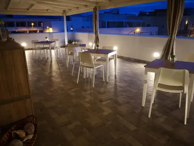 a group of tables and chairs in a restaurant at night at B&B Vivere San Vito Lo Capo in San Vito lo Capo