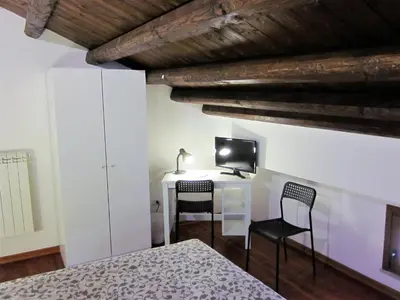 a bedroom with a bed and a desk with two chairs at icalderai in Palermo