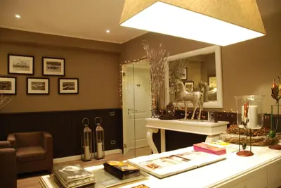 a living room with a mirror and a table with books at Maxim in Palermo