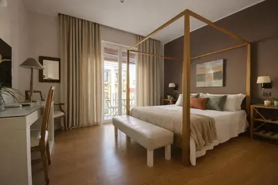 a bedroom with a canopy bed with a white bedspread at Maxim in Palermo