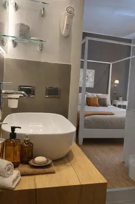 a bathroom with a sink and a bedroom with a bed at Maxim in Palermo