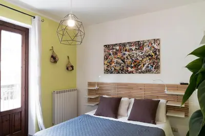 a bedroom with a bed and a painting on the wall at Khalisa Home in Palermo