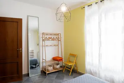 a bedroom with a mirror and a chair and a bed at Khalisa Home in Palermo