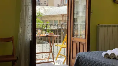 a bedroom with a door open to a balcony at Khalisa Home in Palermo