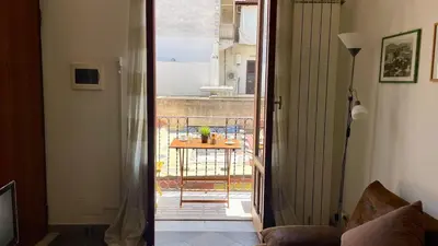a room with a door open to a balcony with a table at Khalisa Home in Palermo
