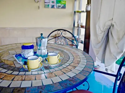 a round table with two cups and a jug on it at Acasaammari in Campofelice di Roccella