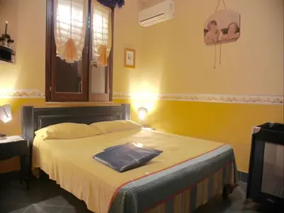 a bedroom with a large bed with yellow walls at Acasaammari in Campofelice di Roccella