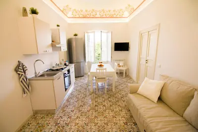 a kitchen and a living room with a couch and a table at Pandora in Porticello