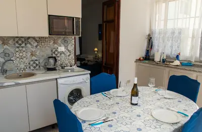 a kitchen with a table with a bottle of wine at MarieRose House Sferracavallo in Sferracavallo
