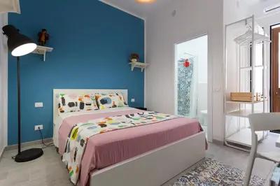 a bedroom with a bed and a blue wall at dallo Zio Totò in Palermo