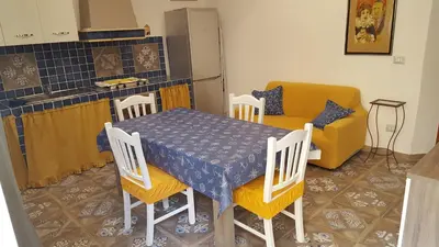 a kitchen with a table and chairs and a couch at Casa Baarìa in Bagheria
