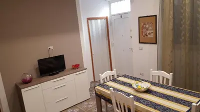 a dining room with a table and a television at Casa Baarìa in Bagheria