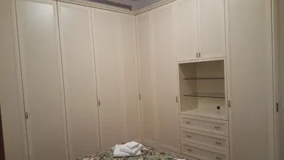a white closet with white cabinets and a bed at Casa Baarìa in Bagheria