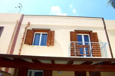 a building with two windows and a balcony at Casa Catalano in San Vito lo Capo