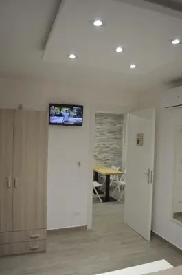 a room with a tv on the wall and a table at Casa Catalano in San Vito lo Capo