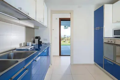 a kitchen with blue and white cabinets and a sink at Nettuno in Cefalù