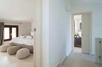 a bedroom with a bed and two ottomans in front of a door at Nettuno in Cefalù