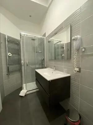a bathroom with a sink and a shower and a mirror at Amuri Room&Suite in Palermo