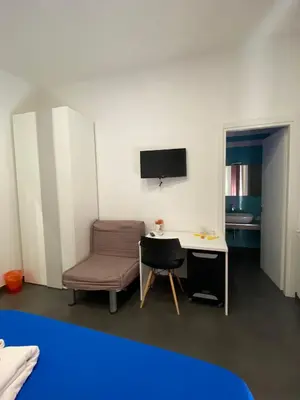 a room with a desk and a chair and a television at Amuri Room&Suite in Palermo