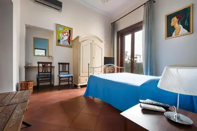 a hotel room with a bed and a table and chairs at B&B Casa Degli Artisti in Palermo