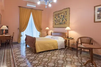 a bedroom with a bed and a desk and a chair at palazzo pantaleo in Palermo