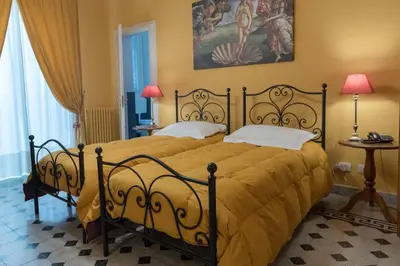 a bedroom with a large bed with a yellow bedspread at palazzo pantaleo in Palermo