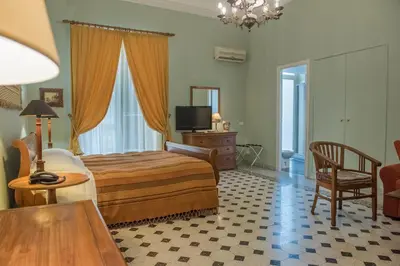 a bedroom with a bed and a table and a chair at palazzo pantaleo in Palermo