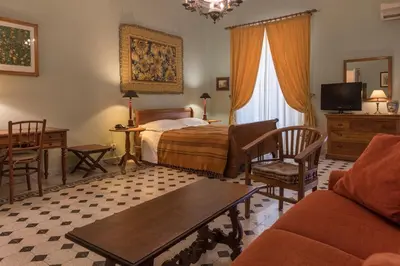 a bedroom with a bed and a couch and a table at palazzo pantaleo in Palermo