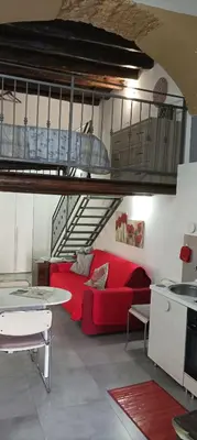 a living room with a red couch and a loft at La Casetta Di Marta ai Quattro Canti in Palermo