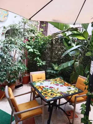 a table and chairs on a patio with plants at Casa Sicana in Palermo