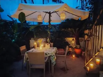 a table with candles and an umbrella on a patio at Casa Sicana in Palermo