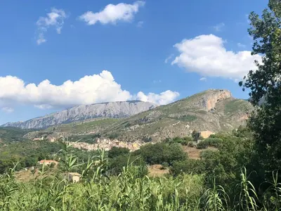 a mountain in the distance with a blue sky and clouds at Agriturismo Ilardo in Collesano