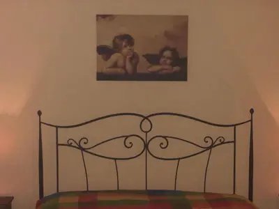 a bed in a bedroom with a painting on the wall at Agriturismo Ilardo in Collesano