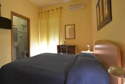 a bedroom with a bed with a blue blanket at Dependance La Mouette in Termini Imerese