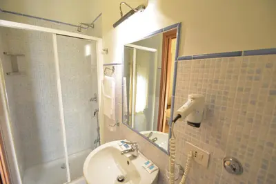 a bathroom with a sink and a shower and a mirror at Dependance La Mouette in Termini Imerese