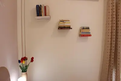 a wall with three books and a vase with flowers at Palazzo Cutelli Bed&Book in Palermo