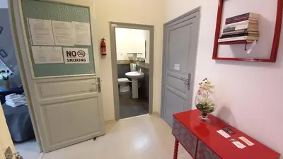 a small bathroom with a door and a red table at Palazzo Cutelli Bed&Book in Palermo