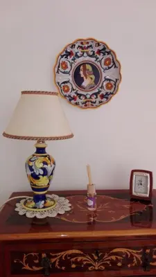 a table with a lamp and a plate on a wall at Casa de Spuches in Palermo
