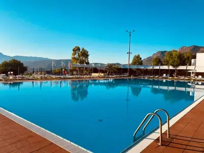 a large swimming pool with blue water at Hotel Torre Normanna in Altavilla Milicia