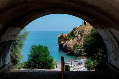a view of a beach through an archway at Hotel Torre Normanna in Altavilla Milicia