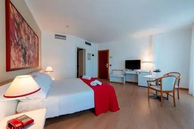 a hotel room with a bed with a red blanket on it at Hotel Torre Normanna in Altavilla Milicia