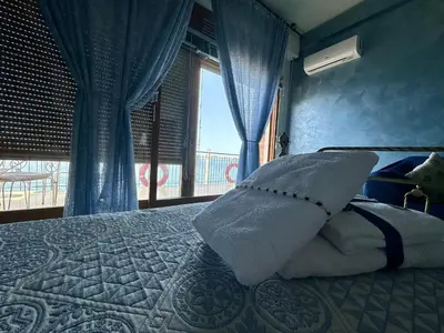 a bedroom with a bed with pillows and a window at Sea Pearl in Casteldaccia