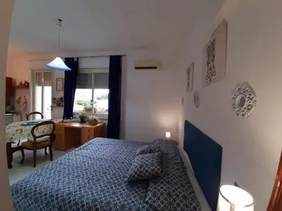 a bedroom with a blue bed and a table at Casa Marisa in Palermo
