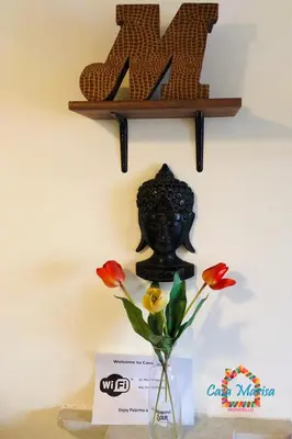 a vase with flowers on a table with a shelf at Casa Marisa in Palermo