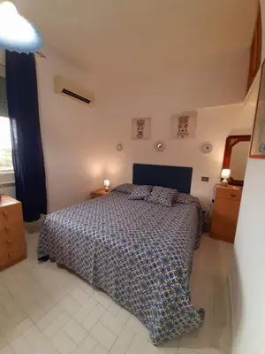 a bedroom with a bed with a blue comforter at Casa Marisa in Palermo